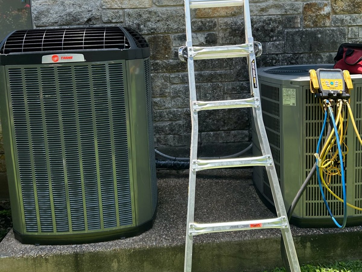 Two new condensers on a shared pad after a double changeout in Austin, TX