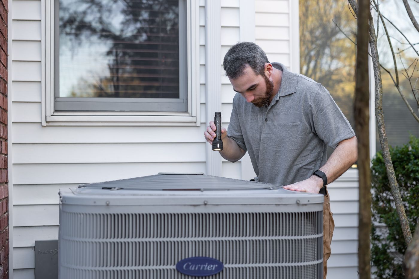 Technician reading gauges on an outdoor unit